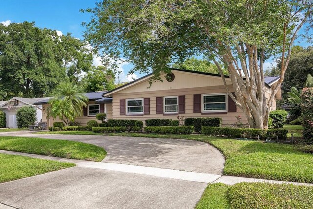 3405 Werber St, Orlando, FL 32806 - ranch-style house featuring curved driveway and a front yard