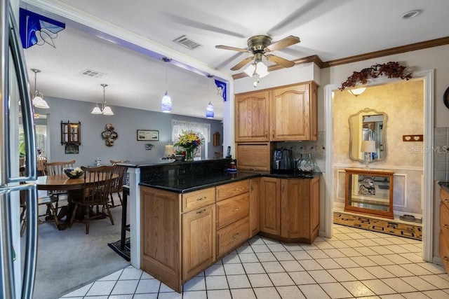 3405 Werber St, Orlando, FL 32806 - kitchen with a ceiling fan, a peninsula, freestanding refrigerator, light tile patterned floors, and ornamental molding