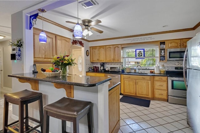 3405 Werber St, Orlando, FL 32806 - kitchen with stainless steel appliances, backsplash, a sink, a kitchen breakfast bar, and crown molding