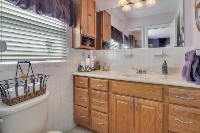 3405 Werber St, Orlando, FL 32806 - bathroom featuring vanity, toilet, tasteful backsplash, a chandelier, and tile walls