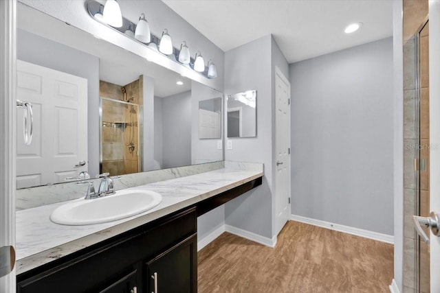 907 Pearly Ridge Ln, Lakeland, FL 33809 - bathroom with wood finished floors, a tile shower, vanity, and baseboards