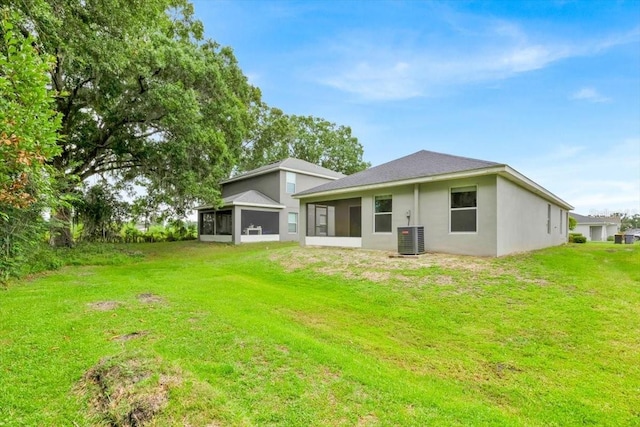 907 Pearly Ridge Ln, Lakeland, FL 33809 - back of house with a sunroom, central AC, a lawn, and a garage