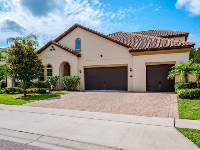 8047 Chilton Dr, Orlando, FL 32836 - mediterranean / spanish-style house featuring decorative driveway, an attached garage, stucco siding, and a tile roof