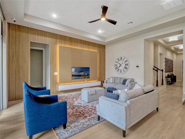 8047 Chilton Dr, Orlando, FL 32836 - living room with light wood-style floors, ceiling fan, a tray ceiling, and stairs