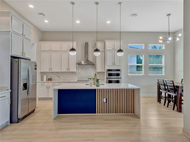 8047 Chilton Dr, Orlando, FL 32836 - kitchen featuring wall chimney exhaust hood, appliances with stainless steel finishes, decorative backsplash, light wood-style floors, and recessed lighting