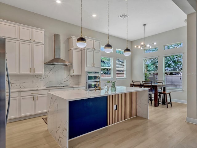 8047 Chilton Dr, Orlando, FL 32836 - kitchen featuring wall chimney range hood, light wood-style floors, decorative backsplash, white cabinets, and recessed lighting