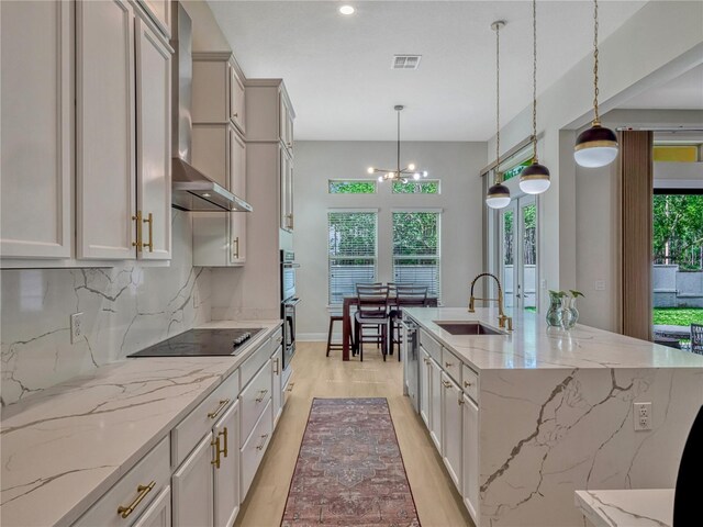 8047 Chilton Dr, Orlando, FL 32836 - kitchen with stainless steel appliances, wall chimney range hood, a sink, decorative backsplash, and a center island with sink