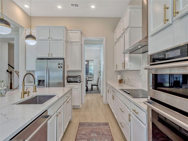 8047 Chilton Dr, Orlando, FL 32836 - kitchen featuring appliances with stainless steel finishes, a sink, white cabinets, light wood finished floors, and recessed lighting