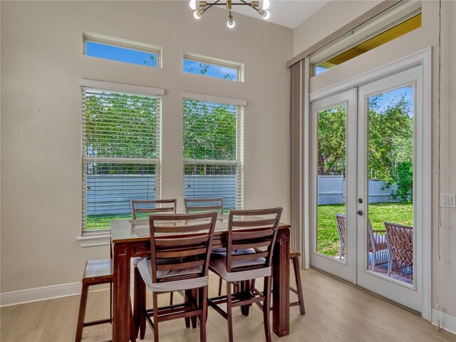 8047 Chilton Dr, Orlando, FL 32836 - dining area with french doors, a chandelier, light wood-style floors, and baseboards