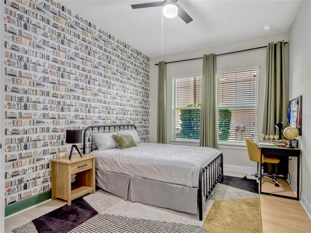 8047 Chilton Dr, Orlando, FL 32836 - bedroom featuring baseboards, an office area, an accent wall, wood finished floors, and a ceiling fan