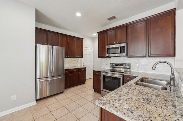 10124 Westpark Preserve Blvd, Tampa, FL 33625 - kitchen with stainless steel appliances, a sink, backsplash, light tile patterned floors, and light stone counters