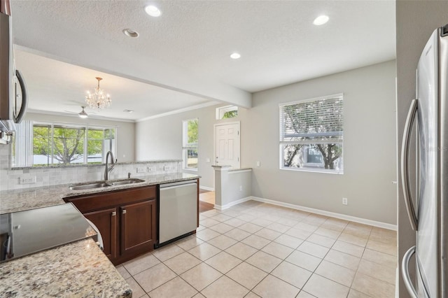 10124 Westpark Preserve Blvd, Tampa, FL 33625 - kitchen with stainless steel appliances, a sink, backsplash, a chandelier, and baseboards