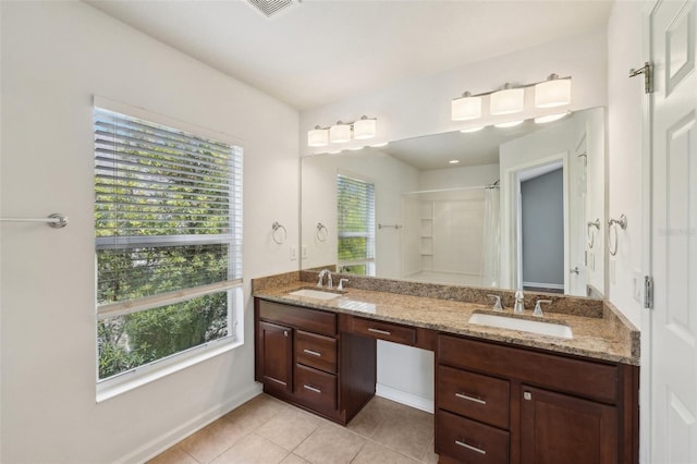 10124 Westpark Preserve Blvd, Tampa, FL 33625 - bathroom featuring healthy amount of natural light, a shower, double vanity, and tile patterned floors