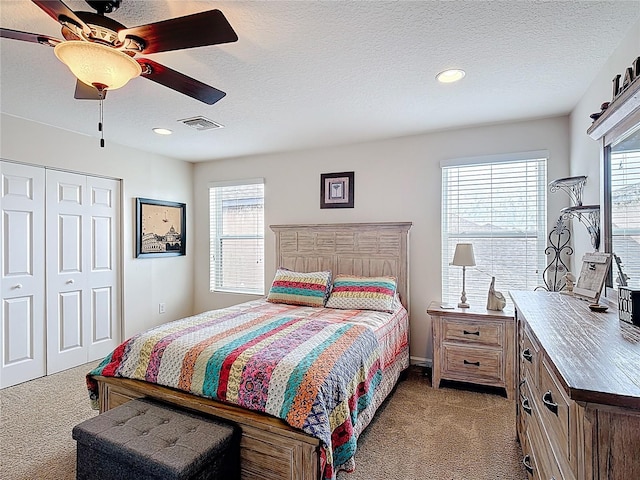 bedroom featuring light carpet, a closet, a ceiling fan, recessed lighting, and a textured ceiling