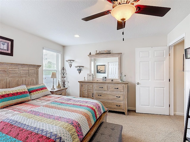 bedroom featuring a textured ceiling, light carpet, ceiling fan, and baseboards