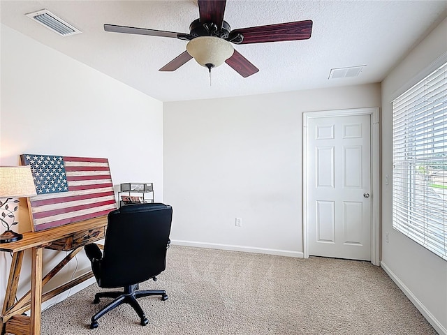 carpeted office with baseboards, a textured ceiling, and ceiling fan