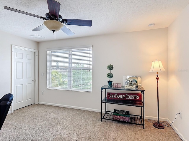 carpeted office featuring a textured ceiling, baseboards, and ceiling fan