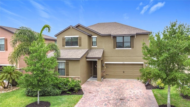 view of front of property with stucco siding, an attached garage, decorative driveway, and roof with shingles