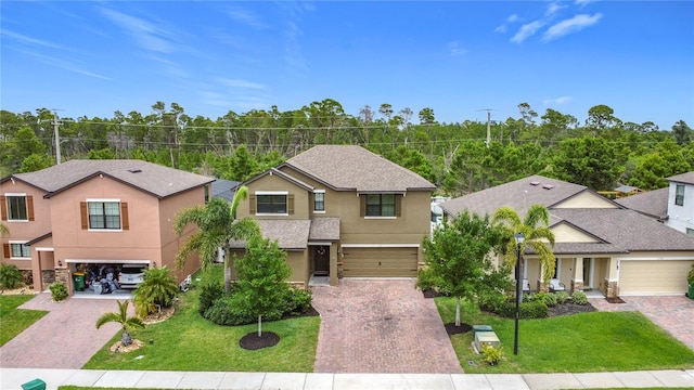 view of front of house with driveway, stucco siding, a garage, and a front yard