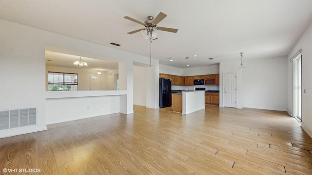 579 Setting Sun Dr, Winter Garden, FL 34787 - unfurnished living room with a chandelier, light wood-style flooring, ceiling fan, and baseboards