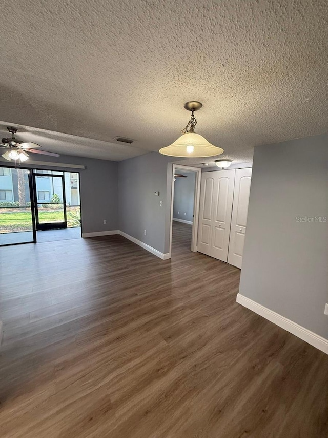 190 Riverbend Dr Unit 102, Altamonte Springs, FL 32714 - spare room with a ceiling fan, a textured ceiling, baseboards, and dark wood finished floors