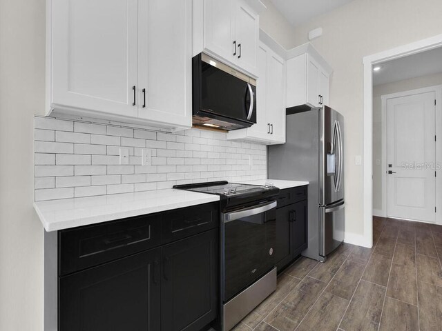 9257 King Hill St, Port Charlotte, FL 33981 - kitchen featuring appliances with stainless steel finishes, white cabinets, light countertops, backsplash, and dark wood-style floors