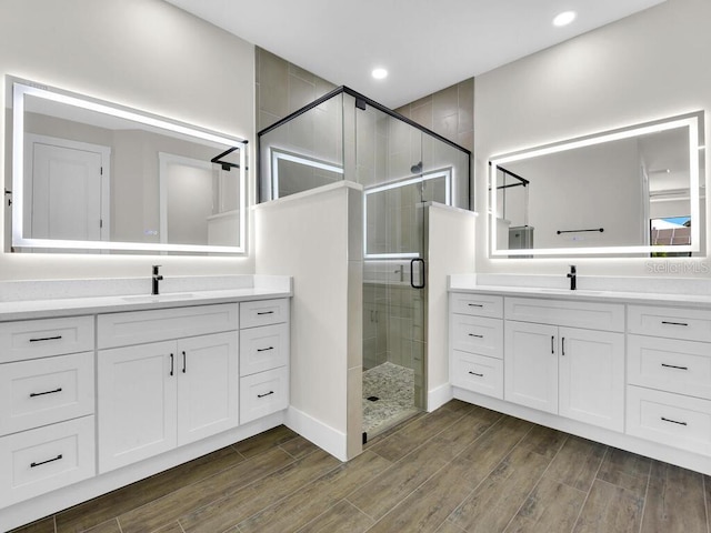 9257 King Hill St, Port Charlotte, FL 33981 - bathroom with a stall shower, wood finished floors, two vanities, and recessed lighting
