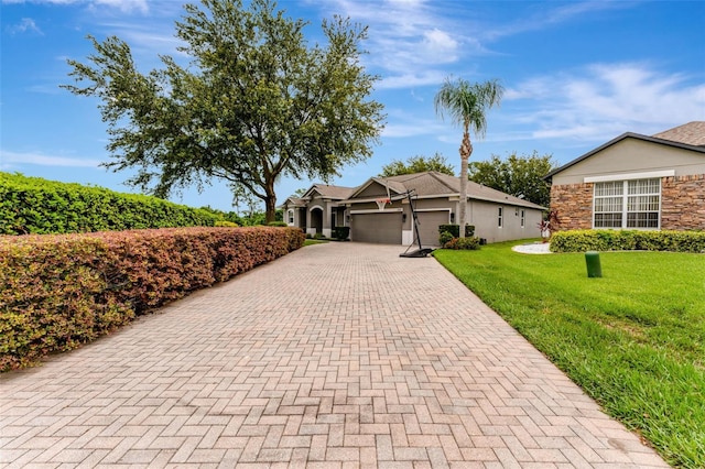 2681 Cabernet Cir, Ocoee, FL 34761 - view of front of house featuring decorative driveway, a garage, a front lawn, and stone siding