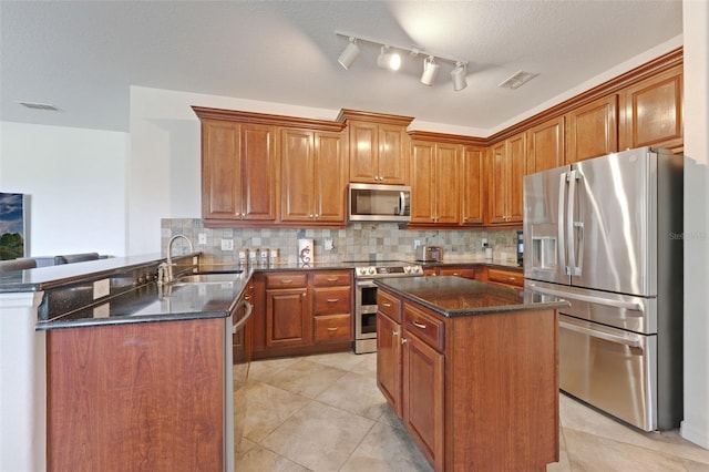 2681 Cabernet Cir, Ocoee, FL 34761 - kitchen with stainless steel appliances, a sink, a peninsula, dark stone counters, and brown cabinetry