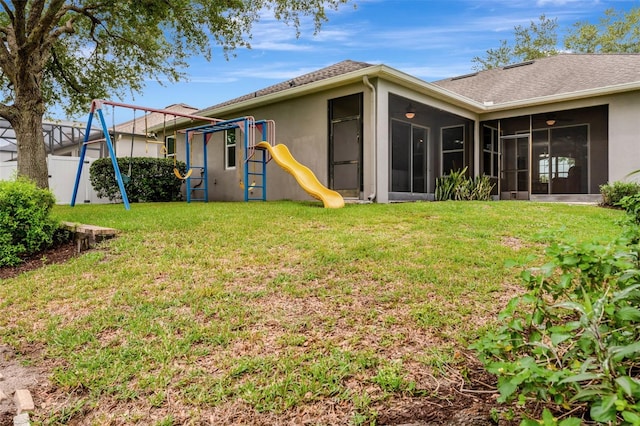 2681 Cabernet Cir, Ocoee, FL 34761 - back of house with a playground, a sunroom, stucco siding, and a shingled roof