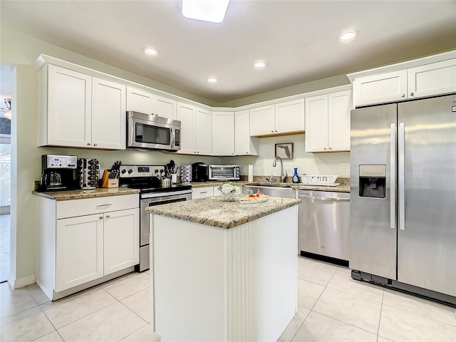 135 Florida Blvd, Crystal Beach, FL 34681 - kitchen featuring stainless steel appliances, a sink, light tile patterned flooring, light stone counters, and recessed lighting