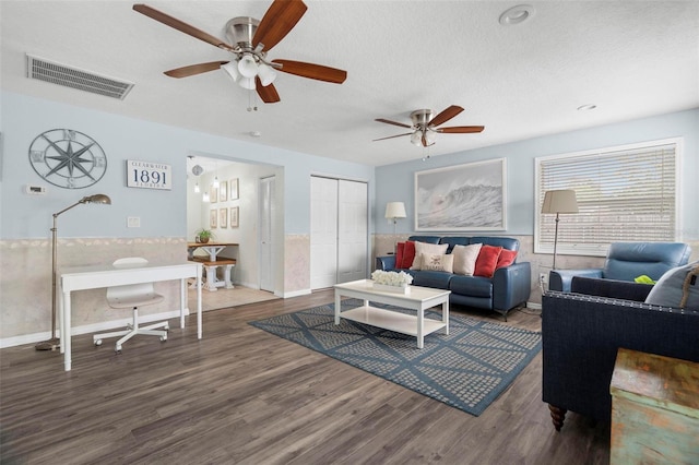 135 Florida Blvd, Crystal Beach, FL 34681 - living room featuring ceiling fan, wood finished floors, a textured ceiling, a wainscoted wall, and baseboards