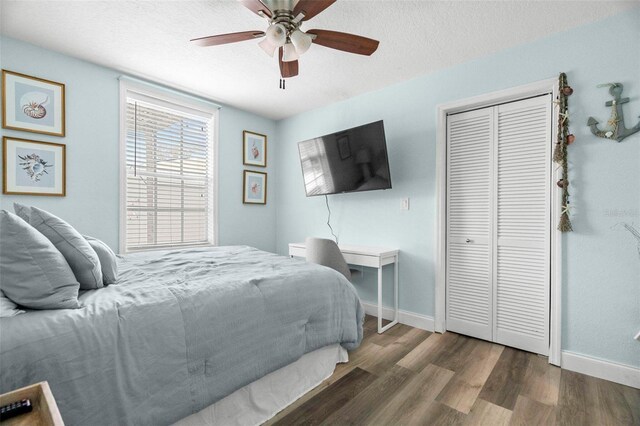135 Florida Blvd, Crystal Beach, FL 34681 - bedroom with wood finished floors, baseboards, a closet, a ceiling fan, and a textured ceiling