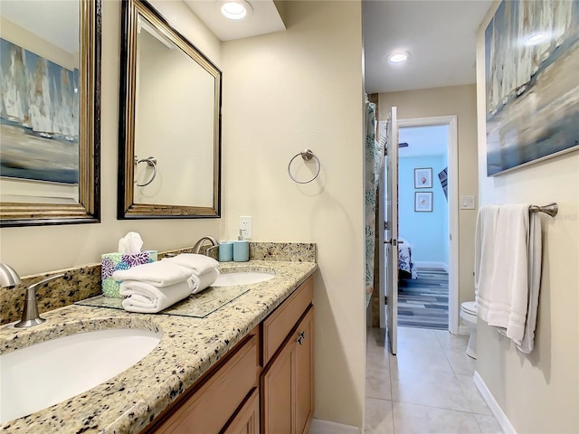135 Florida Blvd, Crystal Beach, FL 34681 - bathroom with double vanity, tile patterned floors, baseboards, ensuite bathroom, and toilet