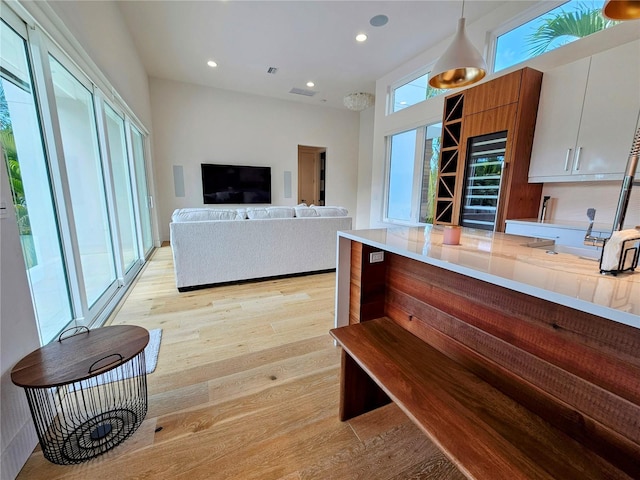 2408 Nassau St, Sarasota, FL 34231 - kitchen with light wood-style flooring, light countertops, white cabinets, recessed lighting, and hanging light fixtures