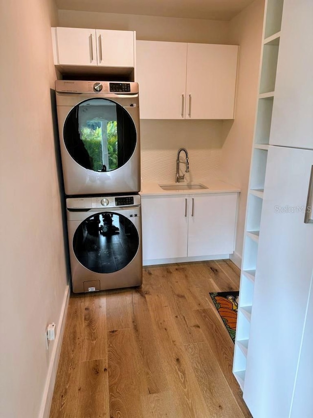 2408 Nassau St, Sarasota, FL 34231 - laundry room featuring stacked washer / drying machine, cabinet space, and light wood finished floors