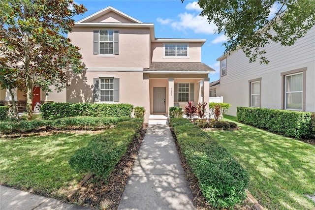 3426 Schoolhouse Rd, Harmony, FL 34773 - traditional-style home with stucco siding, a front yard, and roof with shingles
