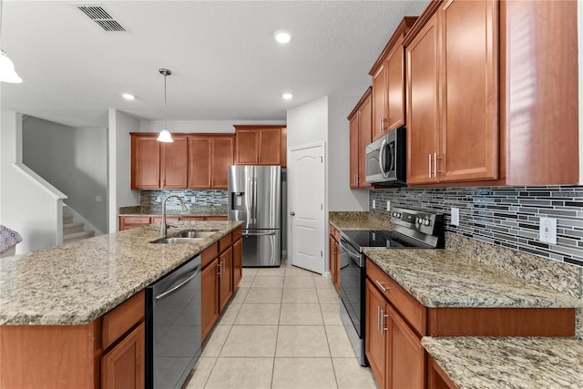 3426 Schoolhouse Rd, Harmony, FL 34773 - kitchen featuring stainless steel appliances, brown cabinets, decorative backsplash, light tile patterned floors, and light stone counters