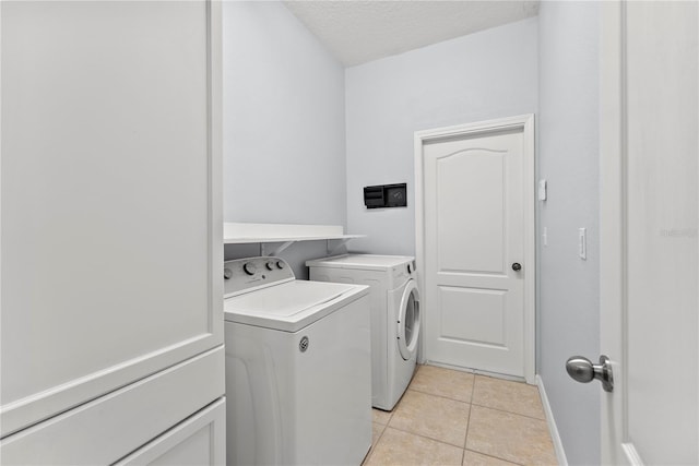 3426 Schoolhouse Rd, Harmony, FL 34773 - laundry room with washer and clothes dryer, light tile patterned floors, and a textured ceiling
