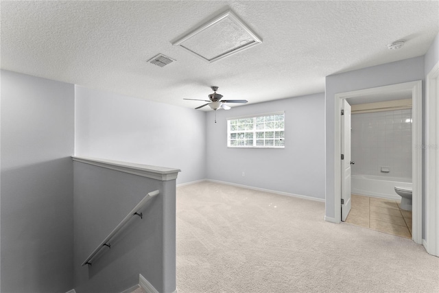 3426 Schoolhouse Rd, Harmony, FL 34773 - unfurnished bedroom with light carpet, attic access, ceiling fan, a textured ceiling, and ensuite bathroom
