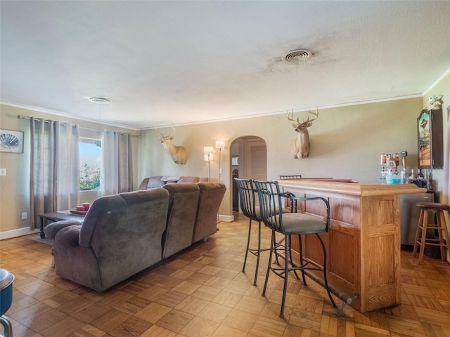12130 Lakeshore Dr, Clermont, FL 34711 - living area featuring arched walkways, crown molding, and a bar