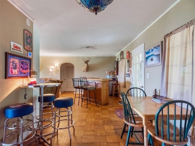 12130 Lakeshore Dr, Clermont, FL 34711 - dining area with crown molding, arched walkways, and a dry bar