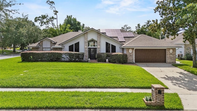 9774 Bohart Ct, Orlando, FL 32836 - view of front facade featuring a garage, a front yard, roof mounted solar panels, and driveway