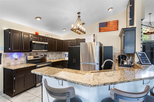 9774 Bohart Ct, Orlando, FL 32836 - kitchen featuring stainless steel appliances, a chandelier, vaulted ceiling, a peninsula, and decorative backsplash