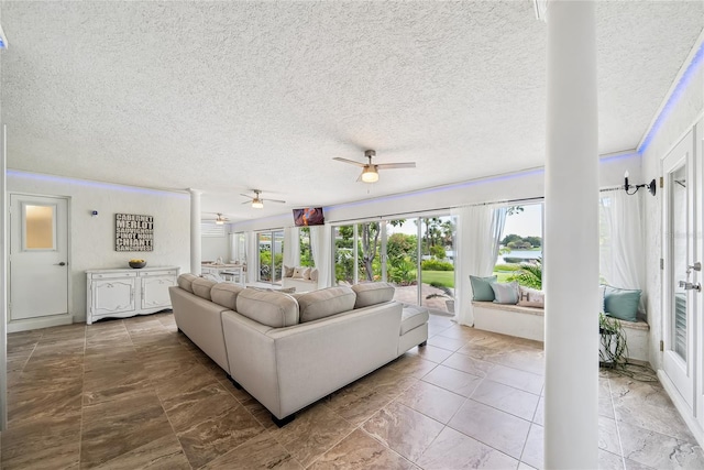 8473 Granada Blvd, Orlando, FL 32836 - living area featuring a ceiling fan, a textured ceiling, decorative columns, and marble finish floors