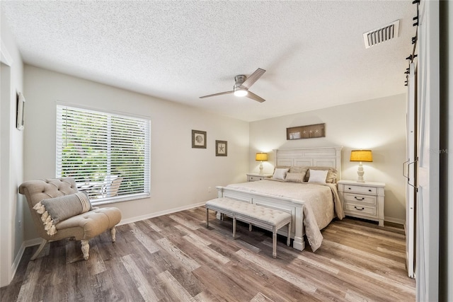 8473 Granada Blvd, Orlando, FL 32836 - bedroom featuring light wood finished floors, a textured ceiling, baseboards, and ceiling fan