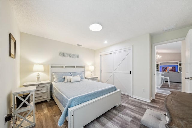 8473 Granada Blvd, Orlando, FL 32836 - bedroom featuring wood finished floors, a closet, baseboards, and a chandelier