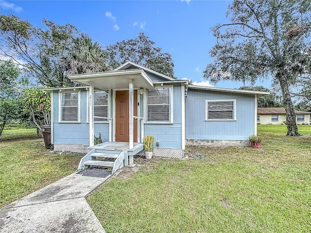 211 N Randolph Ave, Kissimmee, FL 34741 - view of front facade featuring crawl space and a front lawn