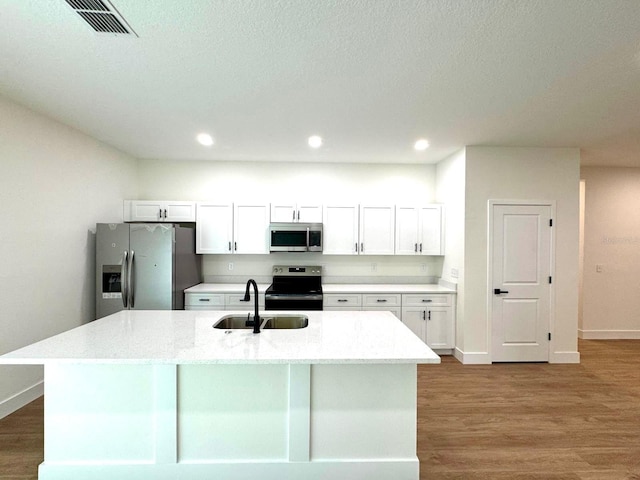 319 Anchovie Ct, Poinciana, FL 34759 - kitchen featuring appliances with stainless steel finishes, a sink, white cabinets, wood finished floors, and recessed lighting