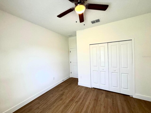 319 Anchovie Ct, Poinciana, FL 34759 - unfurnished bedroom featuring wood finished floors, baseboards, a closet, and ceiling fan